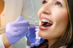 A girl with braces looks up at a light with her mouth agape.